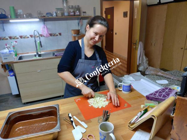 eine junge Frau hackt weiße Kuvertüre