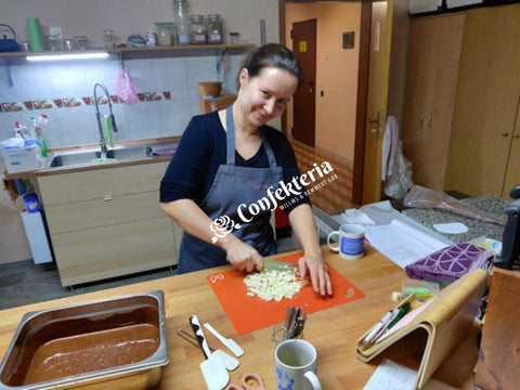 eine junge Frau hackt weiße Kuvertüre