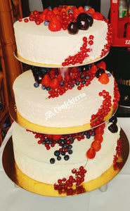 dreistöckige weiße Torte reich mit roten Früchten dekoriert