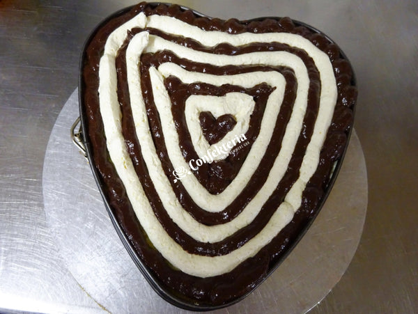 Blick in das Innere der Torte: dunkle Schololadencreme und weiße Buttercreme sind ringförmig aufgespritzt